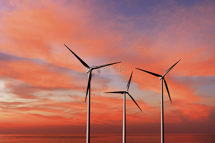 风力涡轮机在大海上空的红日落云层和复制空间的背景下产生可再替代能源态替代能源概念风力涡轮机作为背景日落天空上的替代可再生能源图片