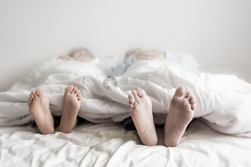 睡在卧室白毯子的床上退休保健与爱的生活方式概念图片