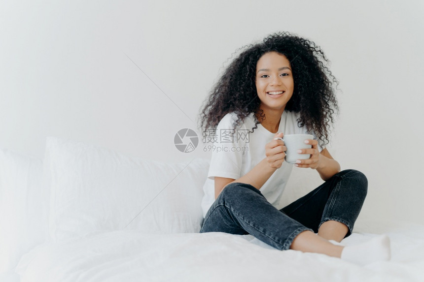 睡在家里早上喝热茶享受家庭气氛愉快的饮料同时在卧室休息人闲暇休息和生活方式的概念图片