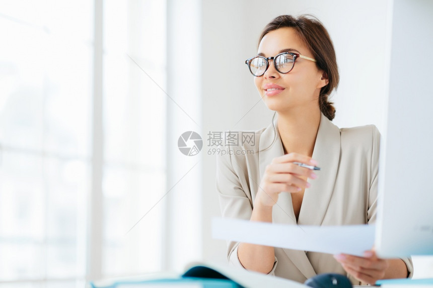 深思熟虑的黑发女人照片正式穿戴眼镜持有笔和纸看着仔细的离开思考如何发展自己的生意工作自由在空间装扮图片