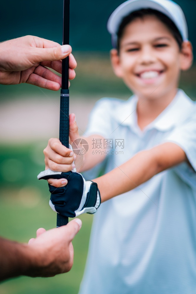 教练在教男孩打高尔夫图片