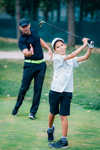 教练在教男孩打高尔夫图片