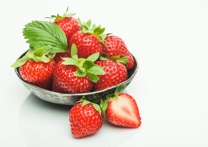 在白色背景的钢碗板上有果子旁边新鲜机草莓在钢碗盘中图片