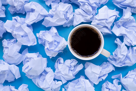 蓝色背景的白折叠纸球圆咖啡杯顶部视图图片