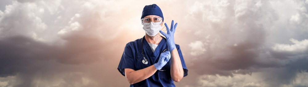 医生或护士在不祥云层上调整外科手套佩戴个人防护设备图片