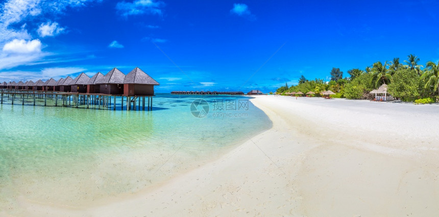 夏季日在热带海滩的沙上在恶劣天气中水别墅bungalows和木桥的全板水bungalows和木桥图片