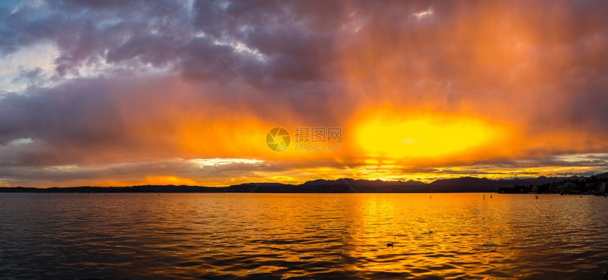 在一个美丽的夏天夜晚在意大利的迦纳湖上日落的全景图片