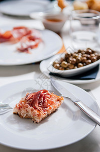 白盘上烤面包的西班牙火腿切片著名的西班牙开胃菜图片