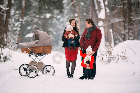 夫妇两推着婴儿车带着孩子雪地合影背景图片
