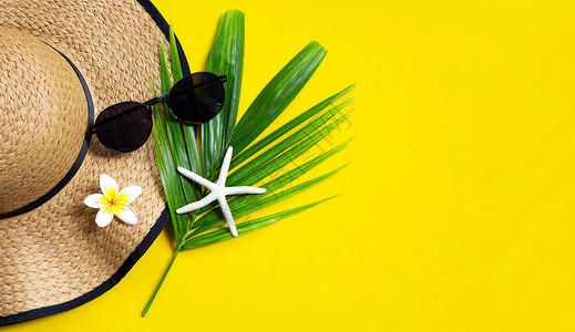 夏季帽子黄色背景的太阳镜享受假日概念复制空间图片