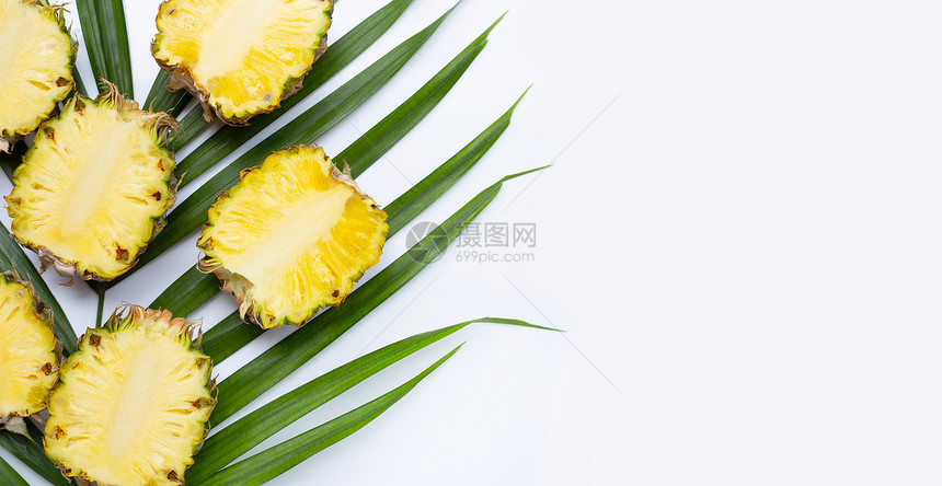 热带棕榈叶上的成熟菠萝图片
