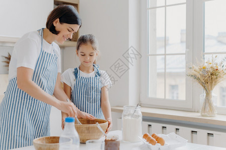 坐在厨房的桌子旁做早餐的母女背景图片