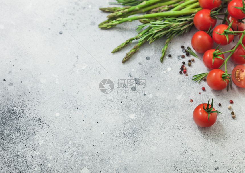 光背景上带树脂樱桃西红柿和淡背景上含迷迭香的浅面食物背景文本空间图片