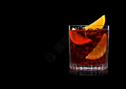 晶玻璃中的白葡萄鸡尾酒有冰块和橙片黑色背景图片