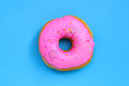 白色孤立甜甜圈蓝色背景上的粉红甜圈顶视图背景
