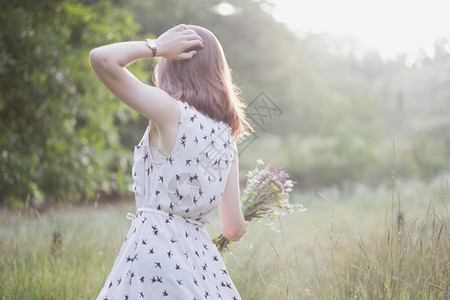 带花束的暑期女孩穿过草地夏天的心情和灵感图片