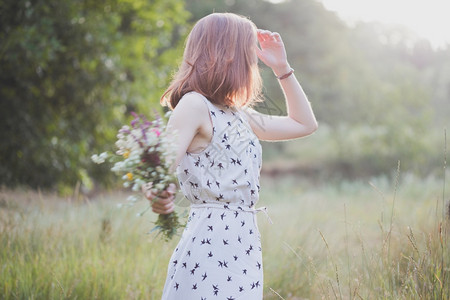 带花束的暑期女孩穿过草地夏天的心情和灵感图片