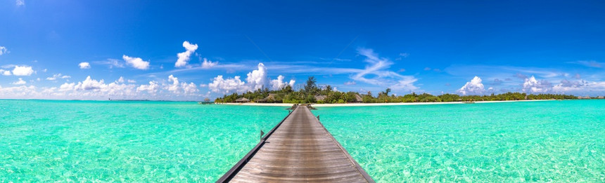 夏季日在热带海滩的沙上在恶劣天气中水别墅bungalows和木桥的全板水bungalows和木桥图片