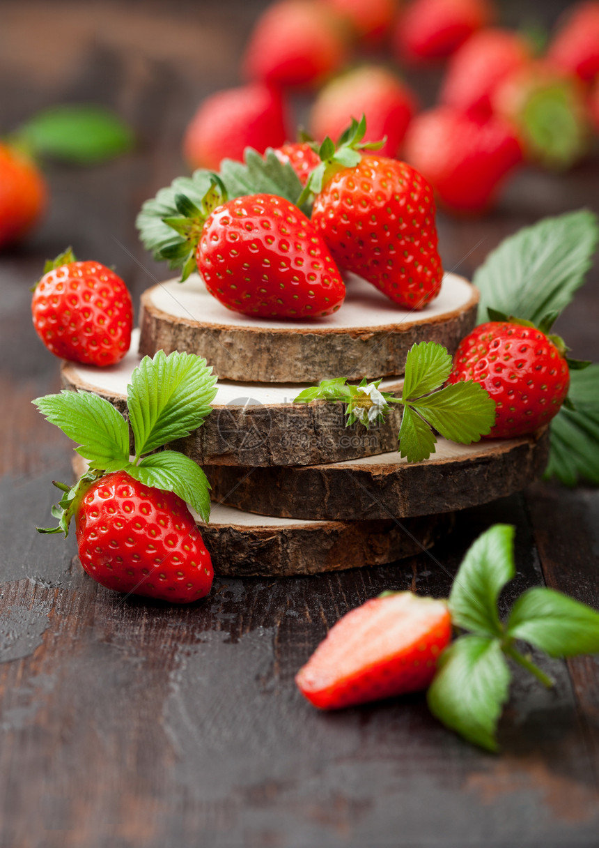 鲜生有机草莓和木本板上的叶子最好夏季果子和很多维他命图片