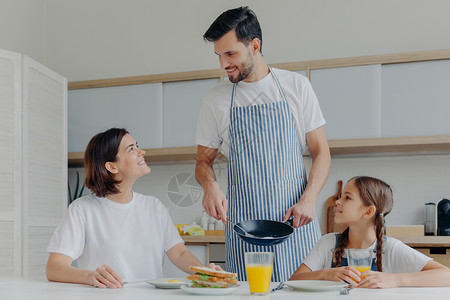 幸福的一家三口在厨房吃早餐图片