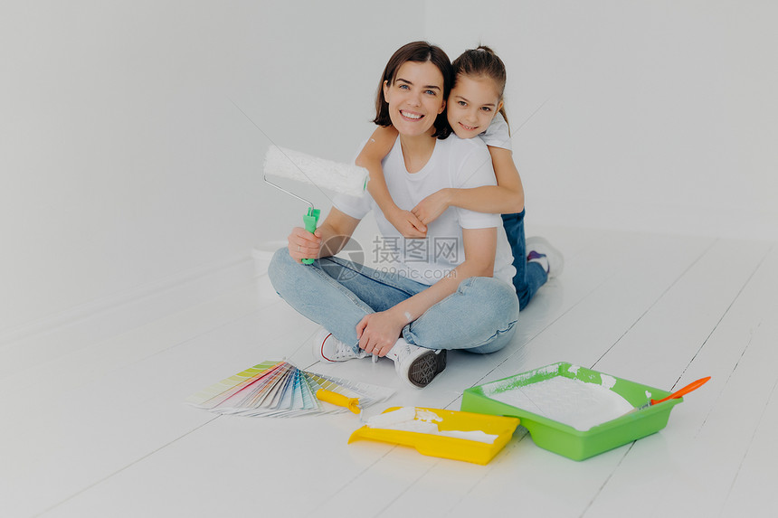 母亲和女儿一起给新房子刷油漆图片