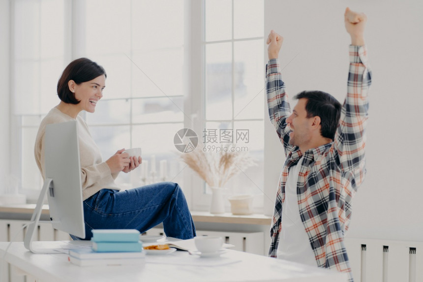 丈夫成功完成工作举起手来和妻子分享自己的喜悦图片