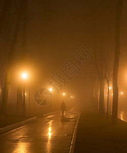 男人走在晚上公园小巷里图片