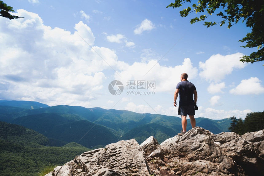 男人站在岩石边缘图片