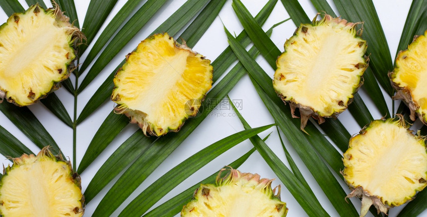 热带棕榈叶上的成熟菠萝图片