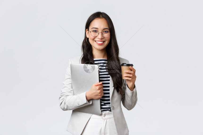 商业金融与就成功的女企家概念自信的英俊女商人在眼镜上和服装喝着外送咖啡并携带工作笔记本电脑商业自信的英俊女商人在眼镜上和服装喝着图片