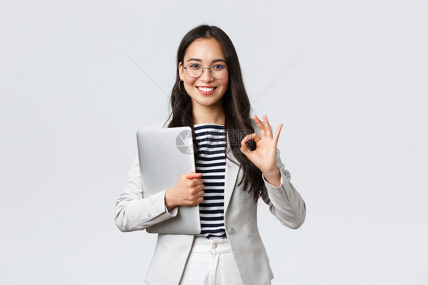 商业金融与就成功女创者概念戴眼镜自信的年轻女商人表现好手势持有笔记本电脑保证最佳服务质量图片