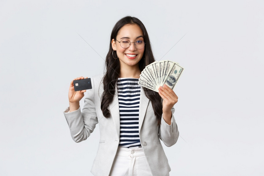 商业金融与就企家货币概念成功的亚洲女企业家与货币概念成功的亚洲女商人在课程中解释如何增加收入持有信用卡与货币微笑的相机图片