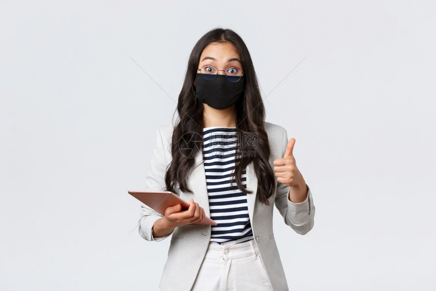 商业金融合作19预防和社会疏离概念女办公室经理人给留下深刻的印象女办公室经理人给留下深刻的印象她有趣想法拇指式戴保护面罩并持有数图片