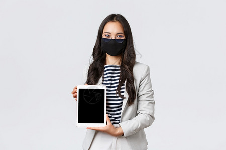 自信的女房地产经纪人在数字平板电脑上为客户交易戴面罩图片