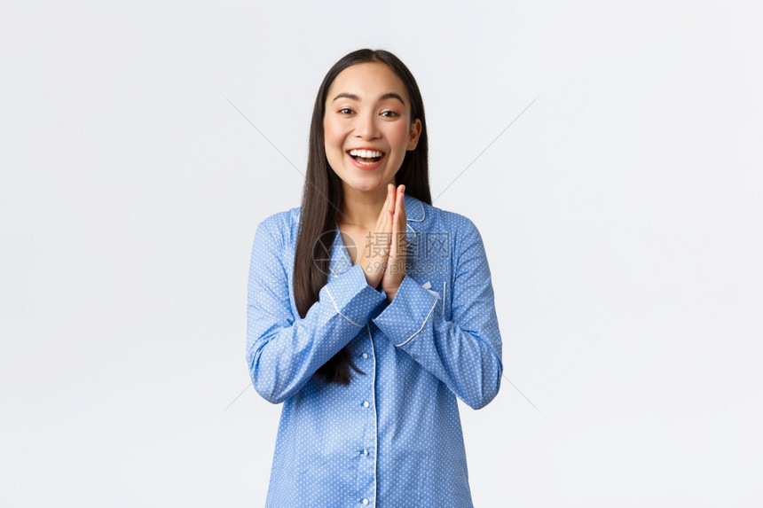 希望并高兴的穿着蓝睡衣亚洲女孩笑高兴将棕榈作为享受伟大成果或利润的乐趣感到幸运等待好消息站立白色背景希望并高兴的亚洲女孩穿着蓝睡图片