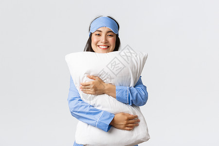 睡着面罩和衣着舒适的枕头满足舒适的表情上床感觉舒适的白色背景图片