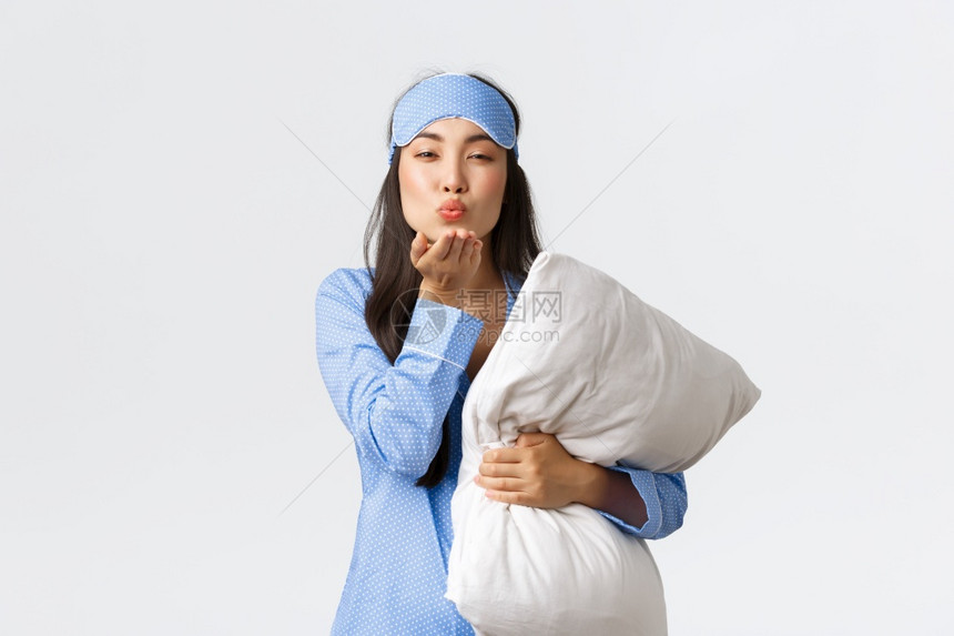 穿着蓝色睡衣面罩拥抱枕头在镜前发出晚安的空吻手戴蓝色睡衣图片