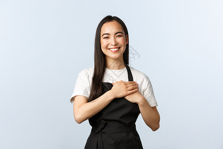 咖啡厅小商业和开办概念可爱愉快的亚洲女咖啡馆工作人员穿着黑色围裙的咖啡师微笑用黑色围裙的咖啡师用心照顾客表达感激之情喜欢工作餐馆背景