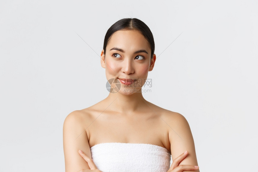 美容和和温泉沙龙概念令人自信和高兴的笑容华丽亚洲女穿着浴巾笑得像左边一样看有思想白背景美容和温泉沙龙概念充满自信和高兴的笑容华丽图片