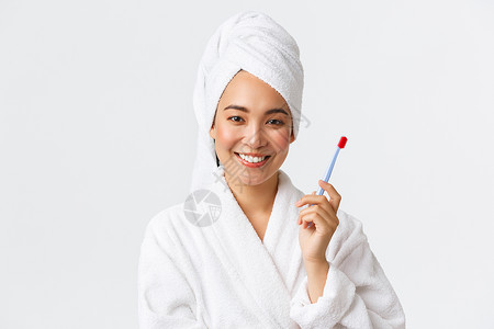 毛巾浴袍穿着浴袍和毛巾洗发用牙刷站立白背景个人护理妇女美貌洗澡和淋浴概念用牙刷洗澡和淋浴概念背景