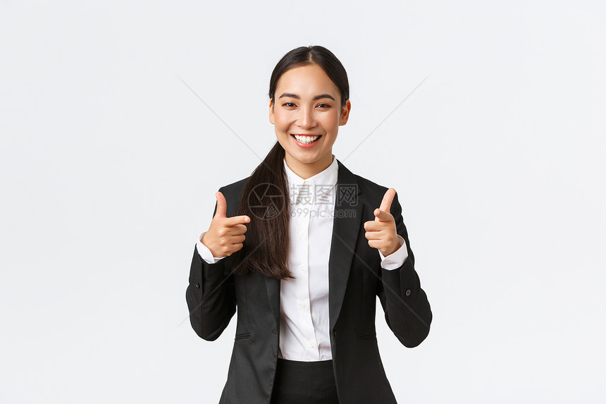身穿黑色西装的有自信笑容女销售员展示了拇指保证产品质量或提供了最佳服务销售经理试图向客户出售某件东西白背景自信的笑脸女销售员展示图片