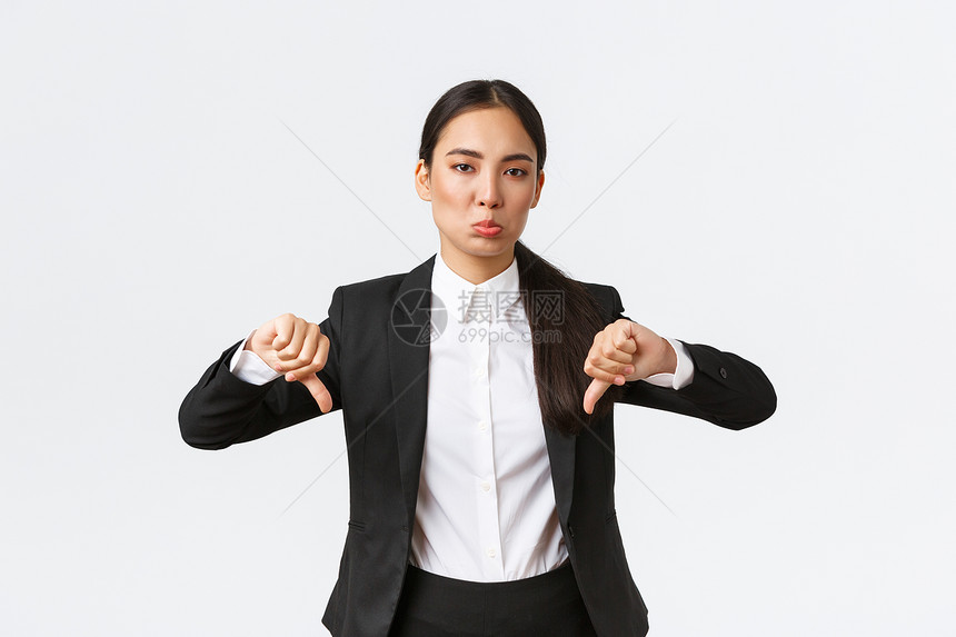 未遭嘲笑的女办公室经理身穿黑西装的售货员身穿黑西装的手缩和严酷的描述一些低劣和可怕的事情抱怨质量差的白背景抱怨身穿黑西装的手缩和图片