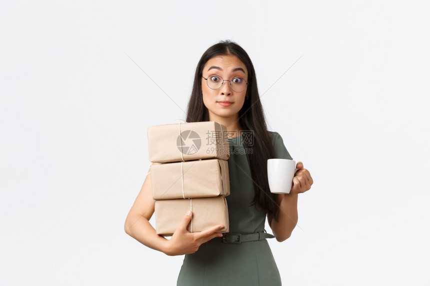 笑着的女士喝咖啡检查装有客户订单的箱子上航运信息管理自己的企业家里网上电子商务店带包裹送货白背景笑着的女士喝咖啡管理自己的生意白图片