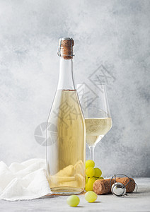 多加衣物和玻璃瓶白自制葡萄酒加和装有轻桌底布的衣物背景