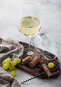 酒箱白玻璃自制葡萄酒装有软木箱和板上的葡萄用浅色桌底布背景