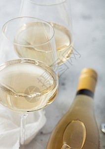 白葡萄酒瓶有两杯晶和在光桌背景上的钢软木板顶部视图macro背景图片