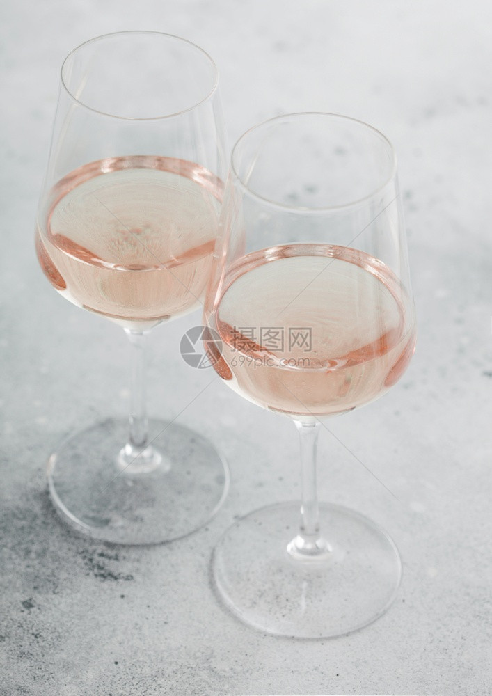 两杯粉红玫瑰自己制的夏日清酒在轻石背景上图片