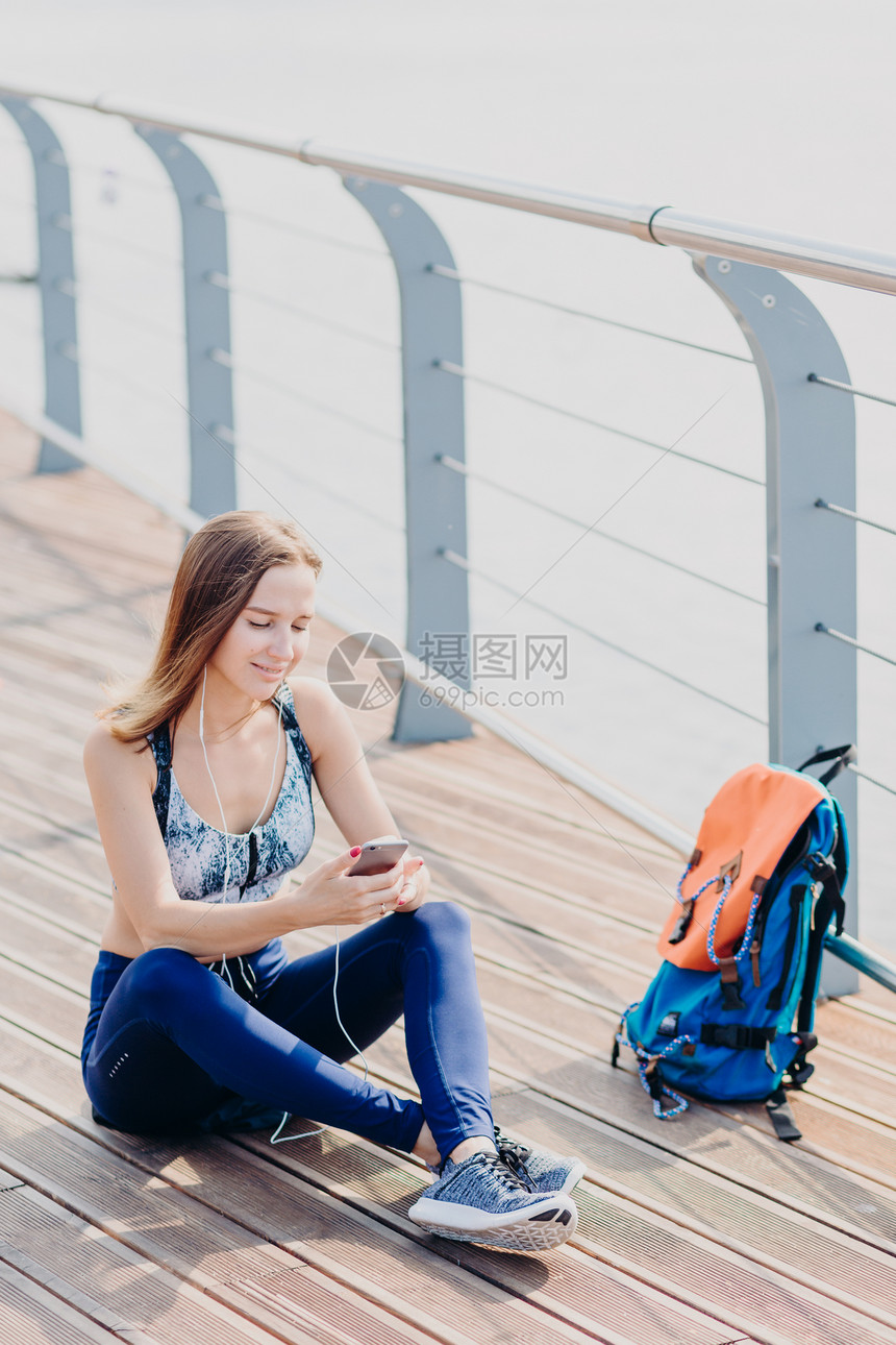 女旅行者在长途跋涉后休息图片