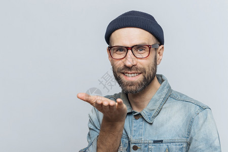 忘保存表情穿着时装的长胡子男欣喜地表达他的爱展示空气之吻现欢快的表情与灰色背景隔绝面带欢快的表情蓝眼中年男子穿着时装在室内做姿势背景