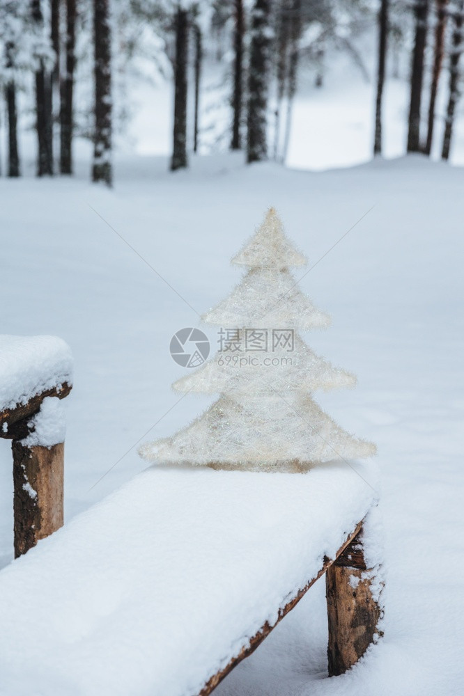 长椅上白人造壁木的垂直镜头上面有雪冬季冻森林节日装饰季概念假期冬季快乐图片